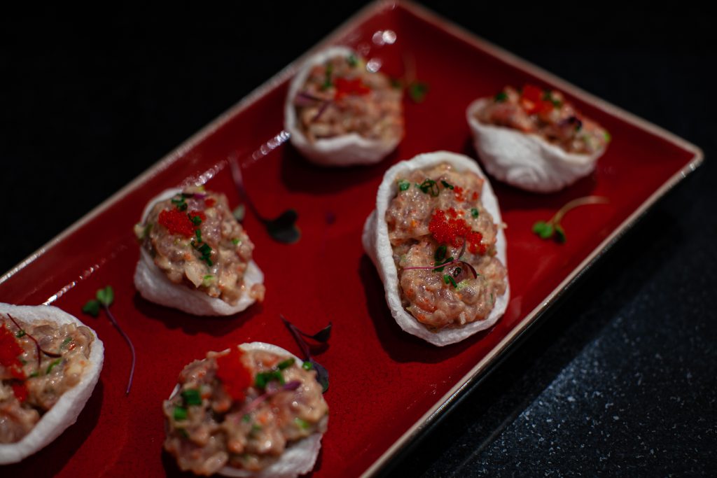 Asian Tuna tartare served as an appetizer with shrimp crackers.