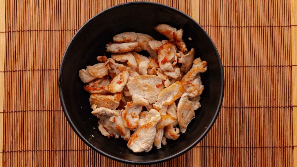 Cooked chicken pieces for the Thai Basil Chicken recipe.